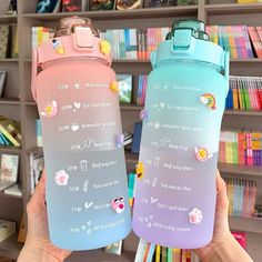 two water bottles with stickers on them in front of a book shelf filled with books