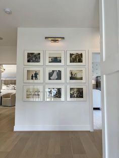 a wall with many pictures hanging on it's side in a white walled room