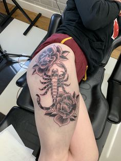 a woman with a tattoo on her thigh sitting in a chair next to a computer