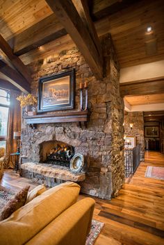 a living room filled with furniture and a stone fireplace