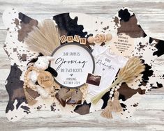 a baby announcement surrounded by other items on a wooden surface with white and black paint