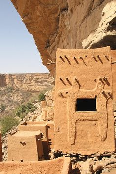 an ancient building in the middle of a desert with mountains in the background and blue sky