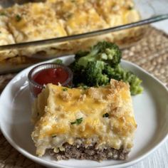 a white plate topped with lasagna and broccoli next to a casserole dish