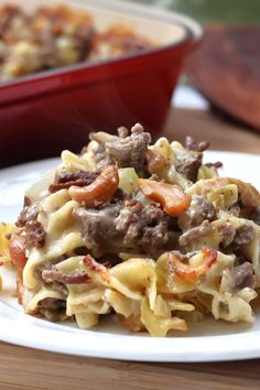 a close up of a plate of food on a table with a casserole dish in the background