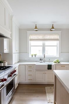 a kitchen with an oven, sink and counter tops in white painted wood paneling