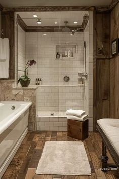 a bathroom with white tile and wooden floors