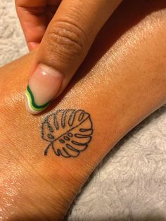 a woman's hand with a small tattoo on her wrist