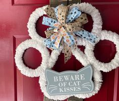 a door hanger that says beware of cat kisses