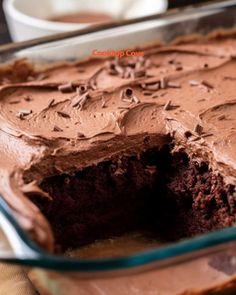 a chocolate cake with frosting in a glass dish