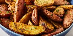 a blue bowl filled with cooked potatoes on top of a table