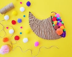 yarn, pom - poms and twine on a yellow background with craft supplies