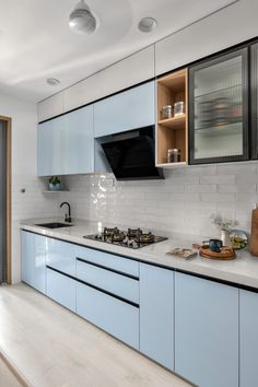 a kitchen with blue cabinets and white countertops is seen in this image from the front view