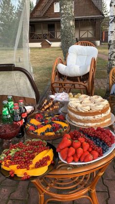 a table filled with lots of food on top of a wooden table next to chairs