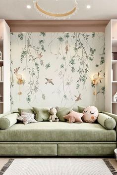 a green couch sitting in front of a book shelf filled with books and stuffed animals