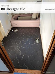 the bathroom floor is covered in black tile and has been stripped off from it's walls