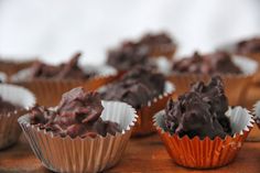 chocolate cupcakes are sitting on a wooden table