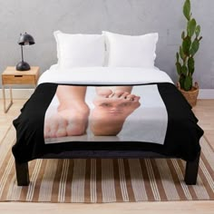 a person's feet and toes on a bed with a white background throw blanket