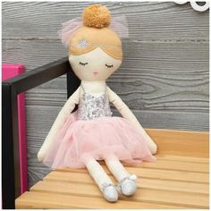 a doll sitting on top of a wooden table