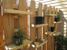 a wooden fence with plants and potted plants on it