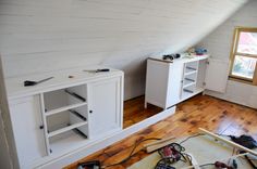 a room with white walls and wooden floors is being worked on by an electrician