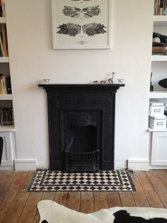 a living room with a black fireplace and white walls