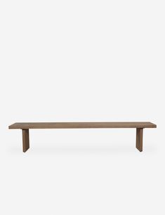 a wooden bench sitting on top of a white wall