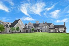 a large house with lots of windows on the side of it and grass in front