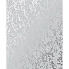 a white and gray wall with some paint splattered on it's surface