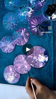 someone is painting purple flowers with watercolors