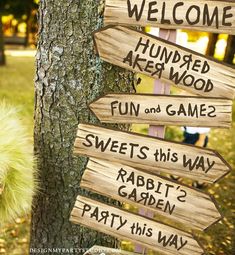 a wooden sign pointing in different directions next to a tree