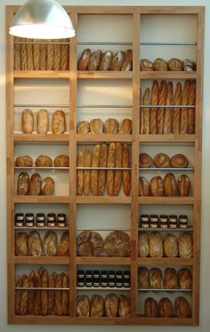 a wooden shelf filled with lots of bread