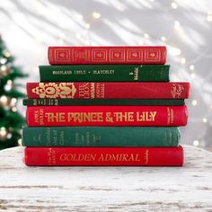 five books stacked on top of each other in front of a christmas tree