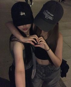 two young women are hugging each other on the street