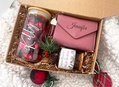 an open gift box filled with christmas treats and other holiday items on a white blanket