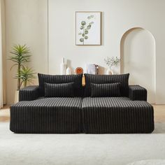 a black couch sitting on top of a white rug