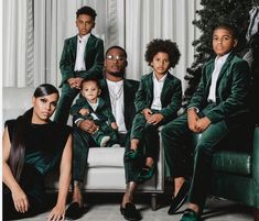 a group of people sitting on top of a couch in front of a christmas tree