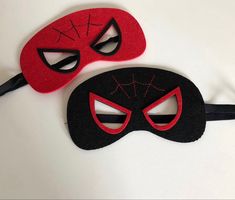 two red and black masks on a white surface