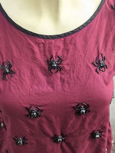 This top is perfect if you're an arachnologist, entomologist or for your Gothic or dark magical wardrobe and fashion! Either way, this is a cute and unique blouse/top. This top is a 2nd hand alteration. The top already had the acrylic black gems on it and I immediately thought they should be turned into into spiders. I hand sewed each glass tube bead to resemble spider legs. All of the 2nd hand garments I sell are hand sewn and beaded in a smoke free, pet friendly home and pre-washed before bead work. The 4th and 5th photos (after the primary photo) show very light ink stains that are otherwise not very noticable. Please excuse the quality of the photos (I'm doing my best while caring for my other baby at the same time). The labels at the base of the neck reads:  Metaphor, Made in India, X Gothic Tops For Fall Costume, Fitted Witchy Top For Costume Party, Gothic Crew Neck Tops For Party, Red Top For Fall Costume Party, Red Tops For Fall Costume Party, Red Gothic Tops For Alternative Fashion, Red Gothic Top For Alternative Fashion, Red Punk Party Tops, Red Gothic Tops