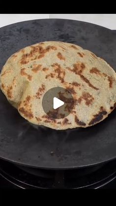 a flatbread is sitting on top of an electric stove with a video showing how to make it