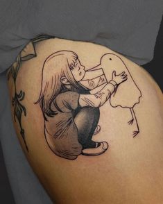 a woman sitting on the ground with a lollipopo tattoo on her thigh