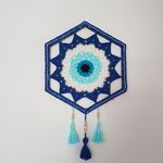 a blue and white wall hanging with tassels