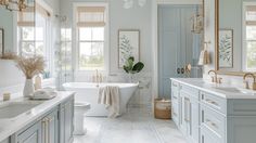 a white bathroom with blue cabinets and gold trimmings on the tub, sink, toilet