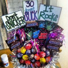 a basket filled with lots of candies on top of a table next to signs