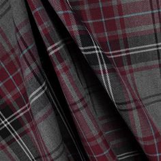 a red and grey plaid fabric with black spots on the bottom, in very close up