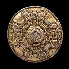 an old gold coin with intricate designs on it