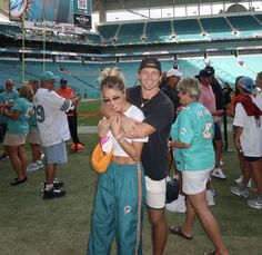 a man and woman hugging each other at a football game