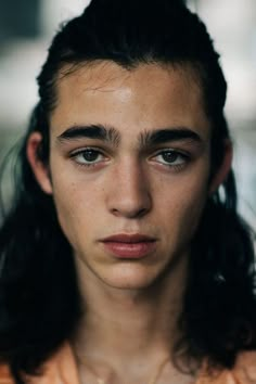 a close up of a person with long hair and an unkempt look on their face