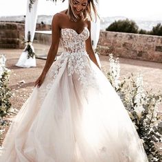 a woman in a wedding dress standing outside