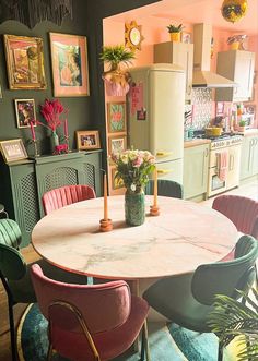 a dining room table with colorful chairs around it