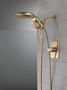 a gold shower head and hand shower in a bathroom